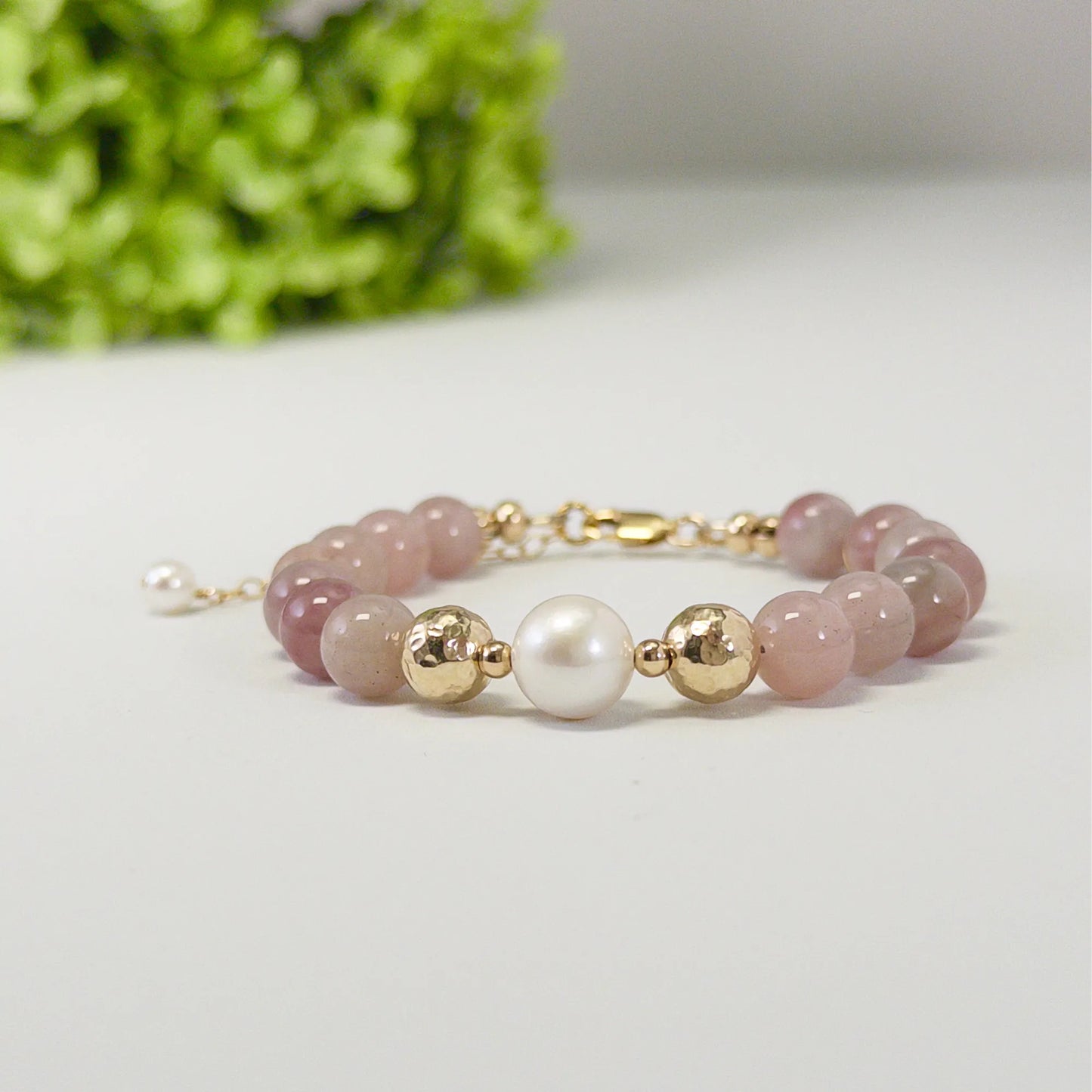 A beaded bracelet featuring mauve rose quartz, premium freshwater pearl, and stamped initial disc. 14k gold filled. MXW Jewellery