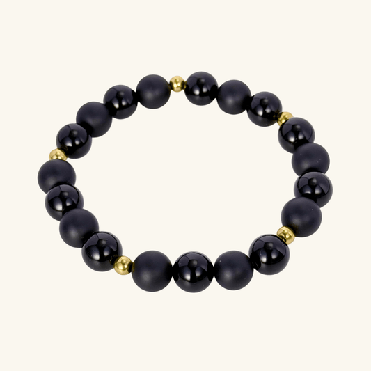 Men’s two-tone bracelet with matte and polished black agate gemstone beads, accented by gold spacers on stretch cord.