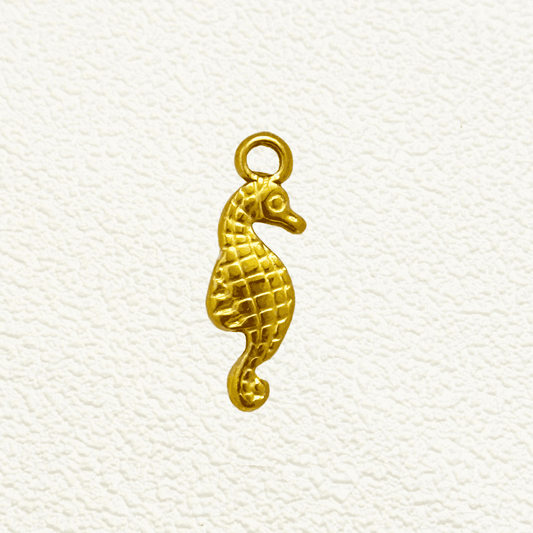 Gold seahorse charm with a textured diamond pattern and curved tail