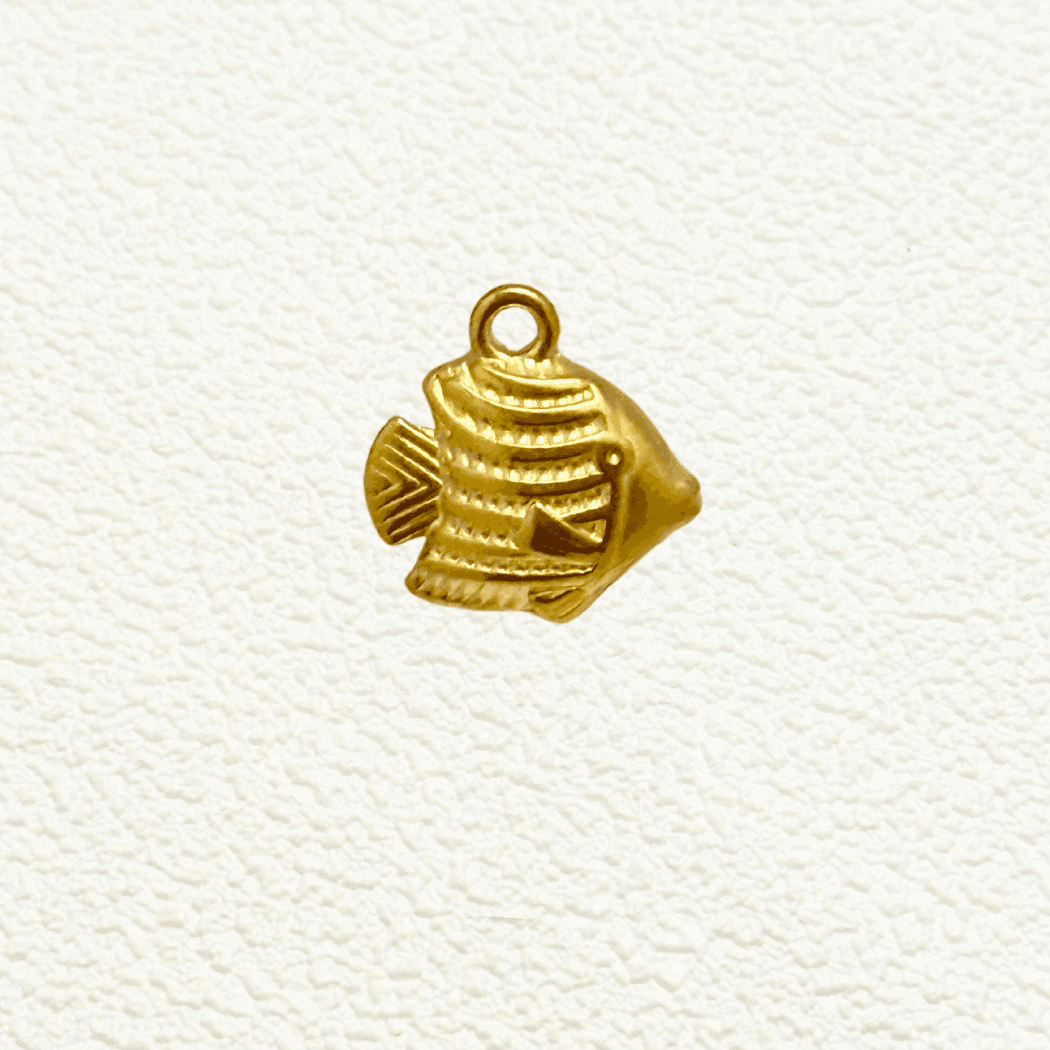 Small gold tropical fish charm with textured detail and solid construction