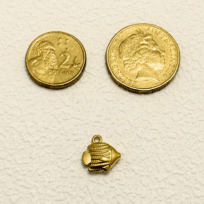 Small gold tropical fish charm with textured detail and solid construction