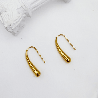 Pair of polished gold tapered raindrop earrings with elongated hook design on white background.