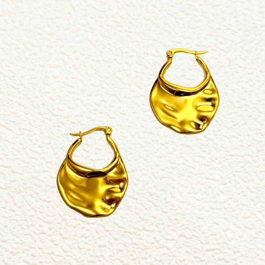 Sculptural molten gold hoop earrings with asymmetrical wave design in glossy finish
