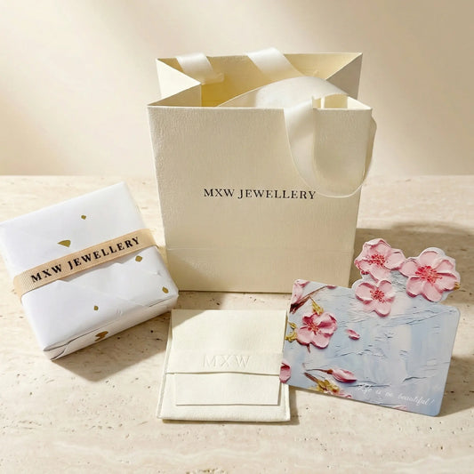 MXW Jewellery branded gift packaging including gift bag, wrapped parcel with ribbon, embossed suede pouch and seasonal message card