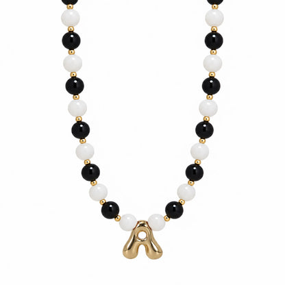 14K gold filled necklace with alternating black onyx and white mother-of-pearl beads, gold spacers and bubble initial letter
