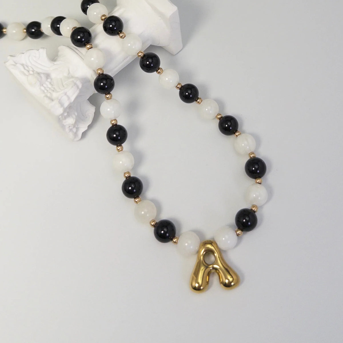 14K gold filled necklace with alternating black onyx and white mother-of-pearl beads, gold spacers and bubble initial letter