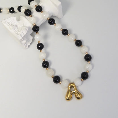 14K gold filled necklace with alternating black onyx and white mother-of-pearl beads, gold spacers and bubble initial letter