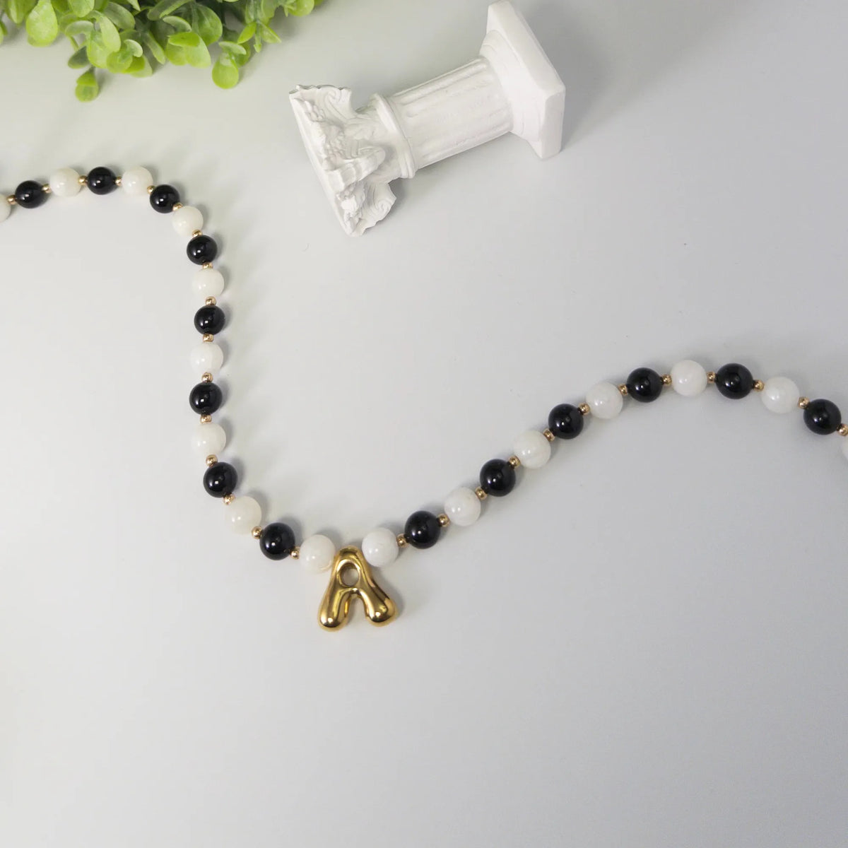 14K gold filled necklace with alternating black onyx and white mother-of-pearl beads, gold spacers and bubble initial letter