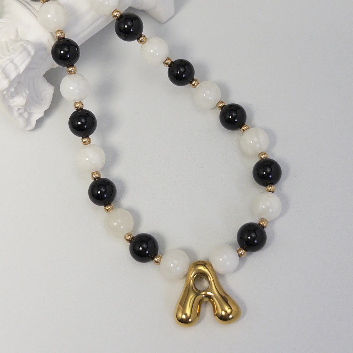 14K gold filled necklace with alternating black onyx and white mother-of-pearl beads, gold spacers and bubble initial letter