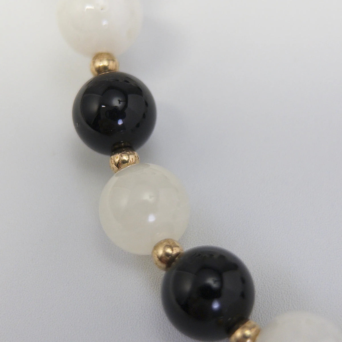 14K gold filled necklace with alternating black onyx and white mother-of-pearl beads, gold spacers and bubble initial letter