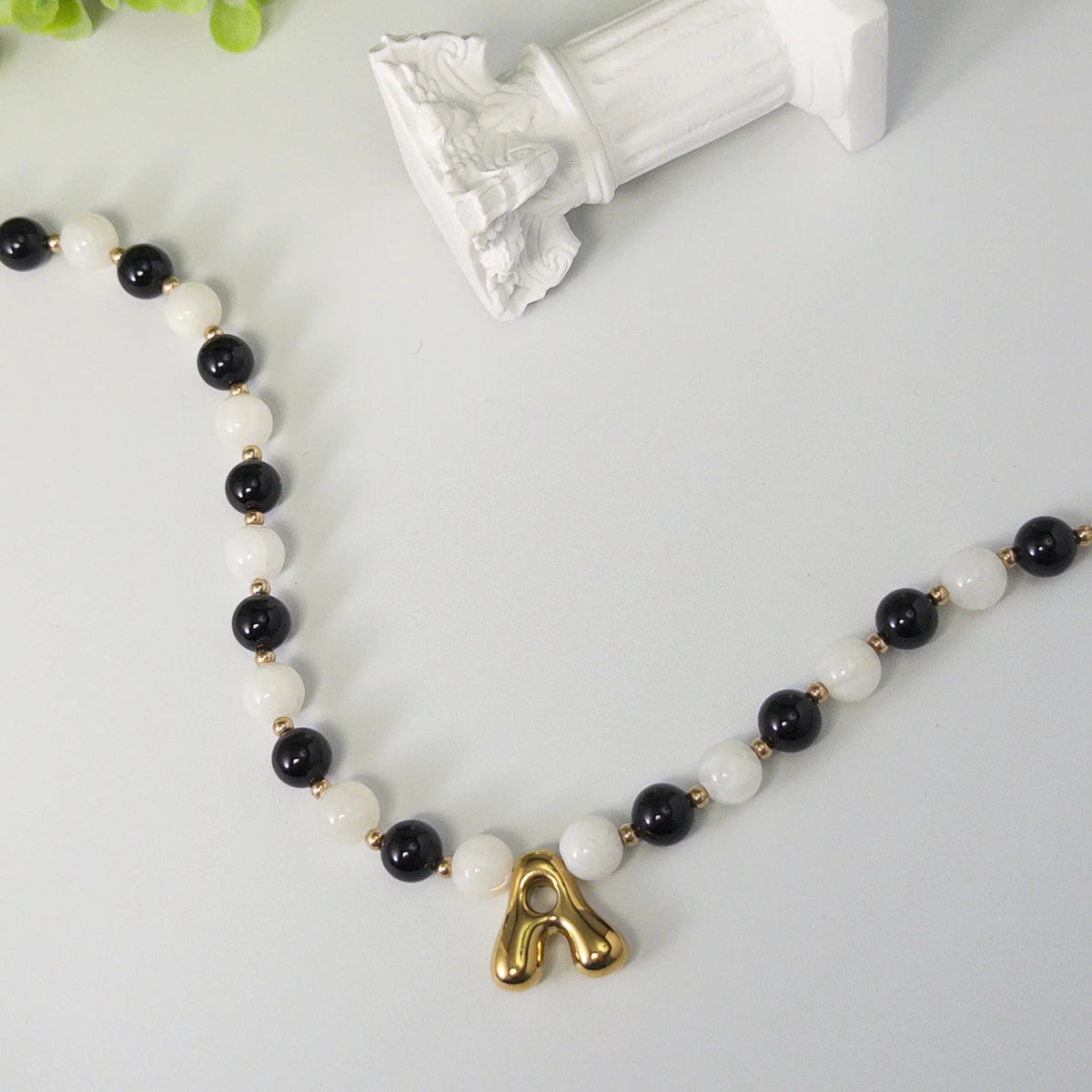 14K gold filled necklace with alternating black onyx and white mother-of-pearl beads, gold spacers and bubble initial letter
