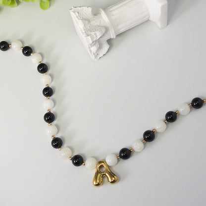 14K gold filled necklace with alternating black onyx and white mother-of-pearl beads, gold spacers and bubble initial letter