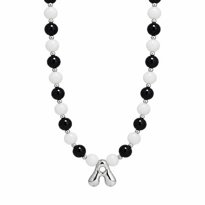 personalised sterling silver necklace with alternating black onyx and white mother-of-pearl bead, gold spacers and bubble initial