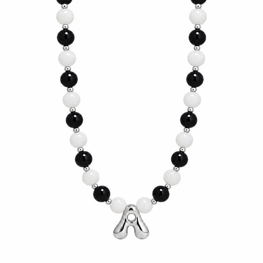 personalised sterling silver necklace with alternating black onyx and white mother-of-pearl bead, gold spacers and bubble initial