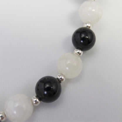 personalised sterling silver necklace with alternating black onyx and white mother-of-pearl bead, gold spacers and bubble initial