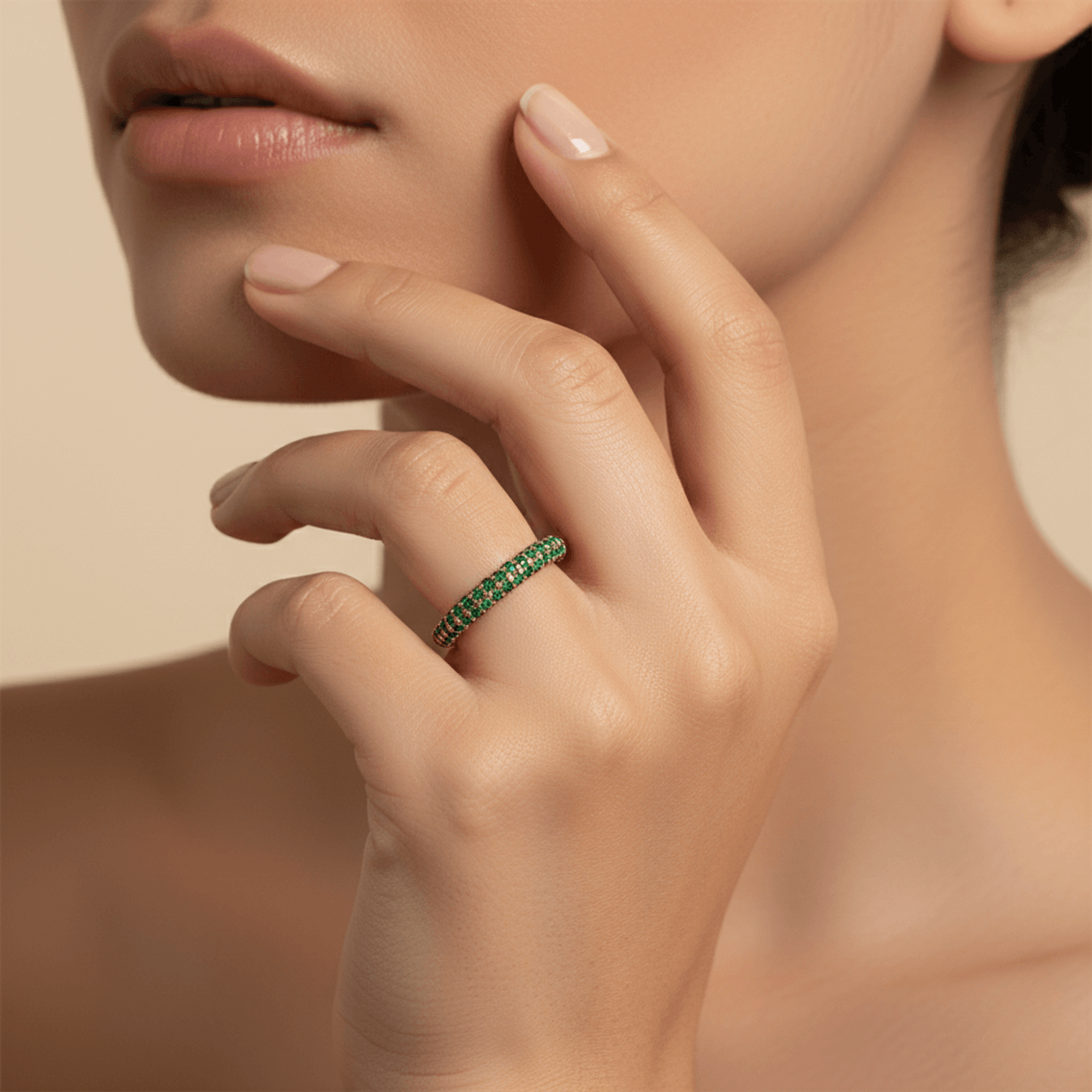Gold pavé ring with emerald-green crystals in a curved arc design.
