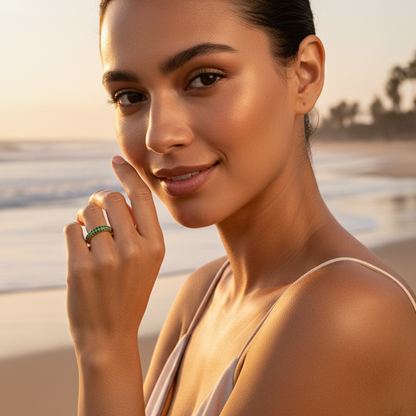 Gold pavé ring with emerald-green crystals in a curved arc design.