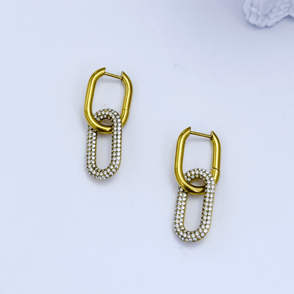 Gold pavé link drop earrings with an elongated sparkling charm hanging from a smooth gold huggie.