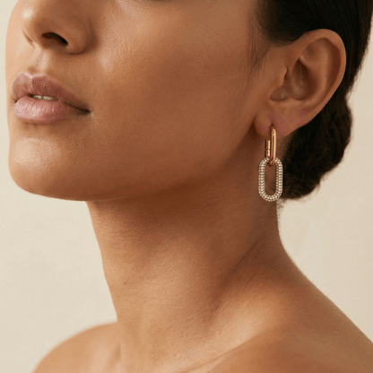 Gold pavé link drop earrings with an elongated sparkling charm hanging from a smooth gold huggie.