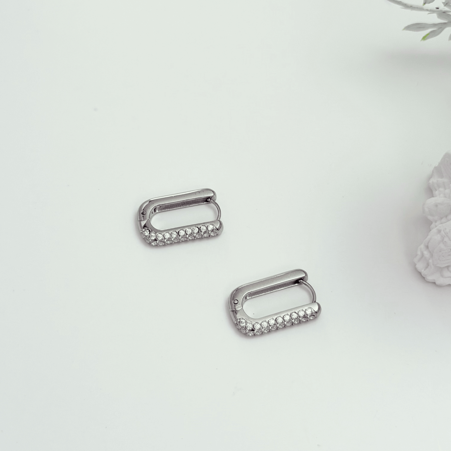 Pavé rectangular silver huggie earrings with crystal detailing.