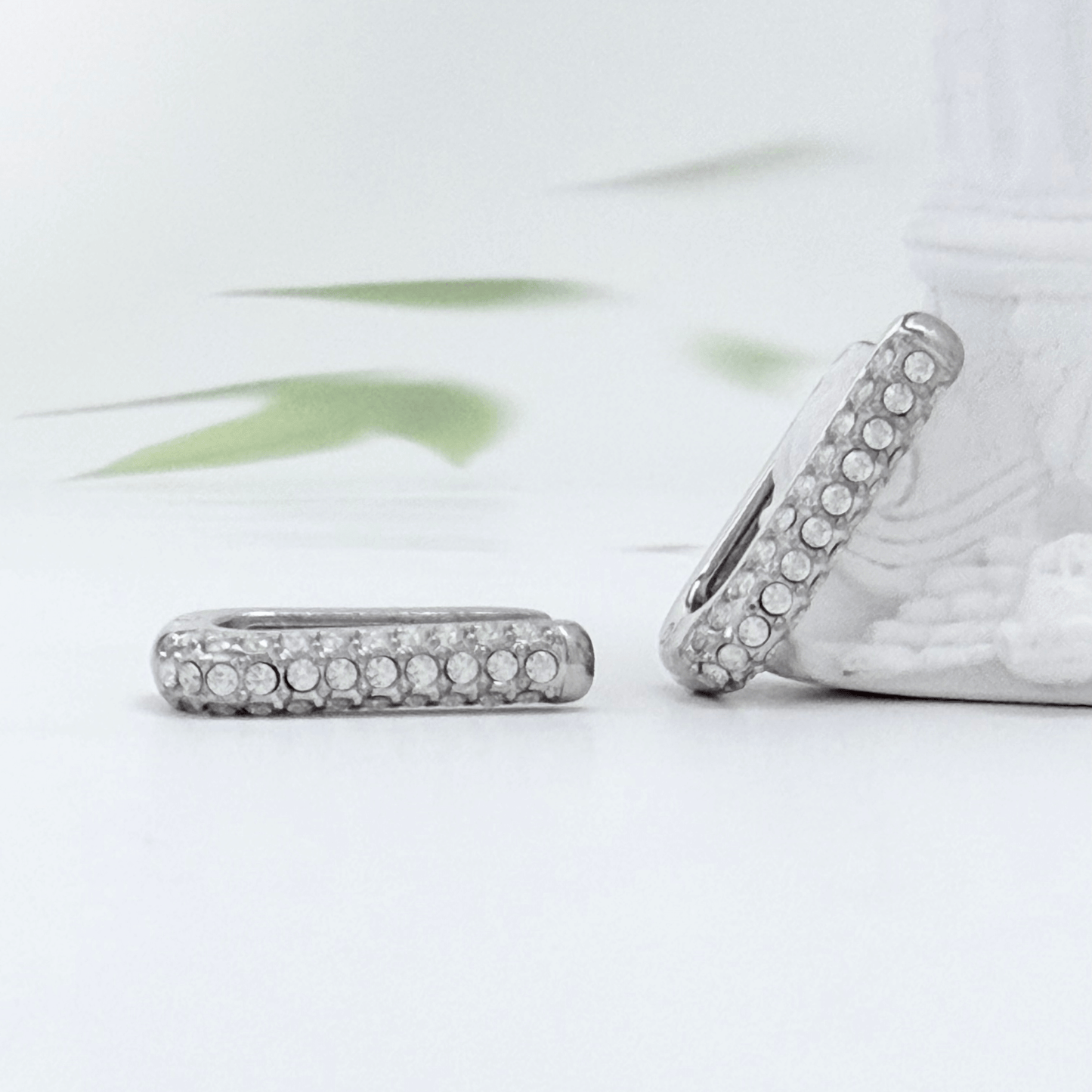 Pavé rectangular silver huggie earrings with crystal detailing.