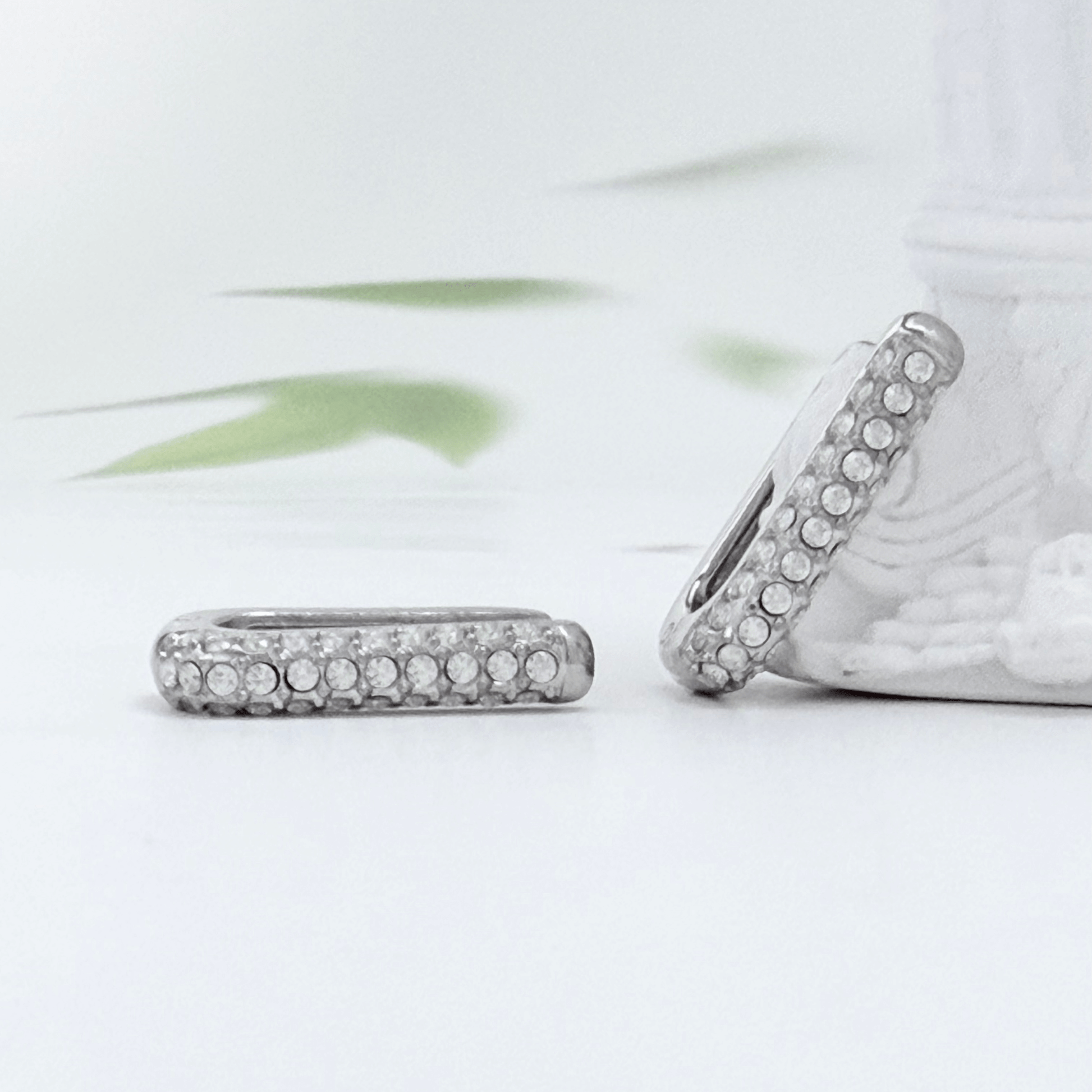 Pavé rectangular silver huggie earrings with crystal detailing.