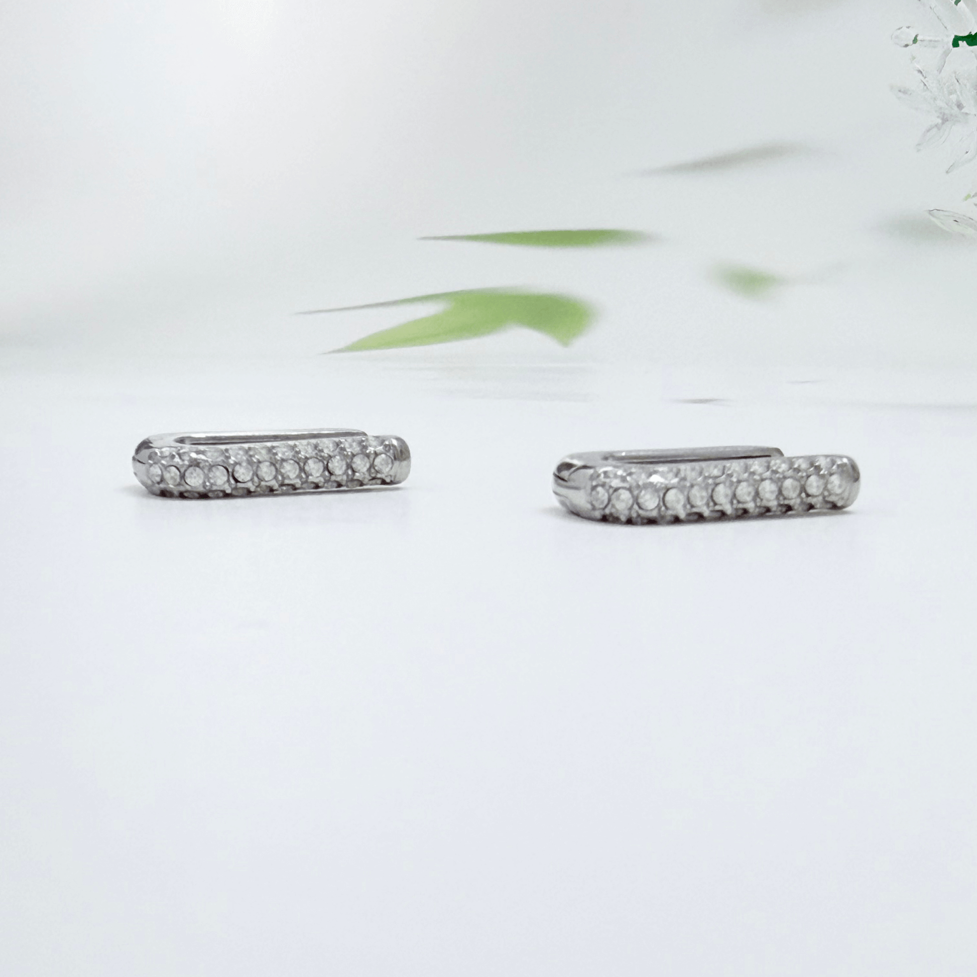 Pavé rectangular silver huggie earrings with crystal detailing.