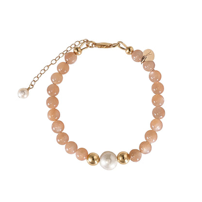 A beaded bracelet featuring peach moonstone beads, premium freshwater pearl, and a stamped initial disc, 14k gold filled. MXW Jewellery