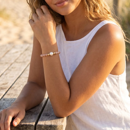 A beaded bracelet featuring peach moonstone beads, premium freshwater pearl, and a stamped initial disc, 14k gold filled. MXW Jewellery