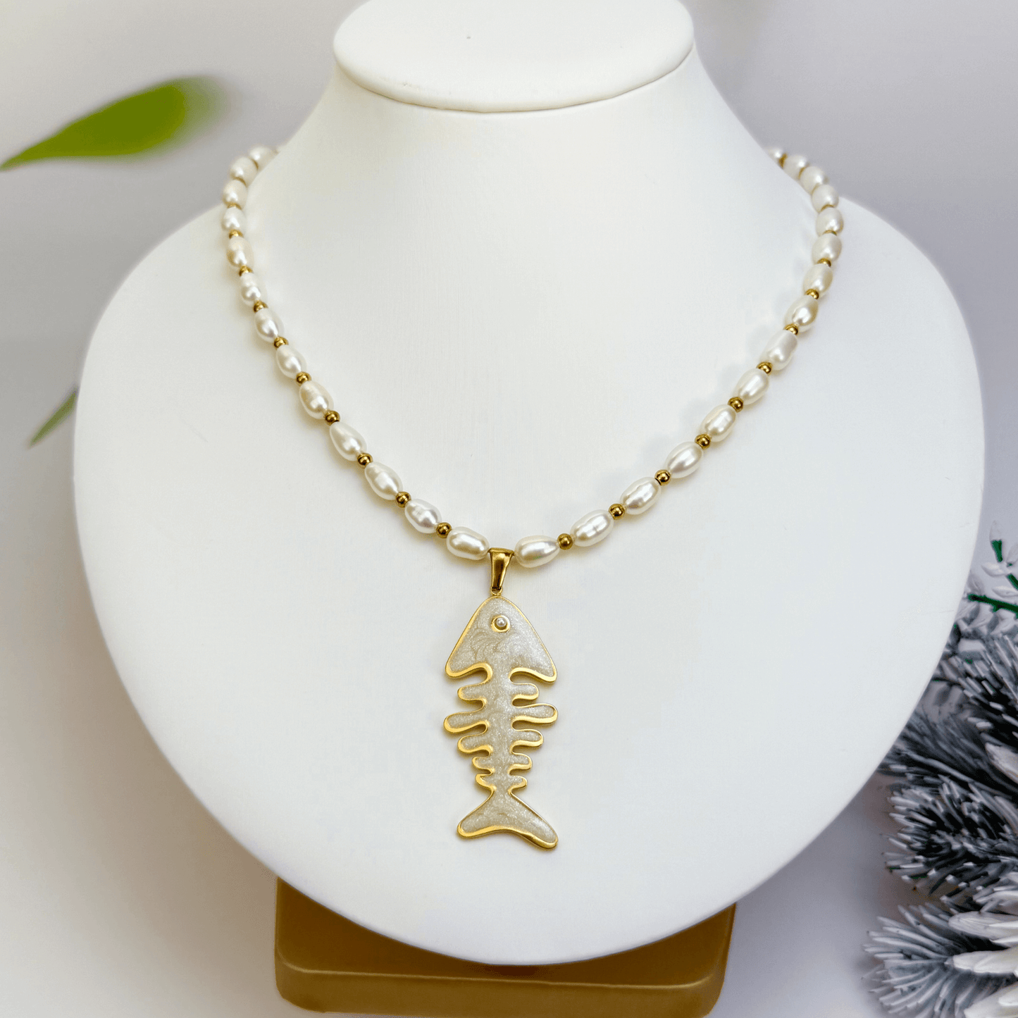 Pearl and gold fishbone necklace symbolising resilience and good fortune