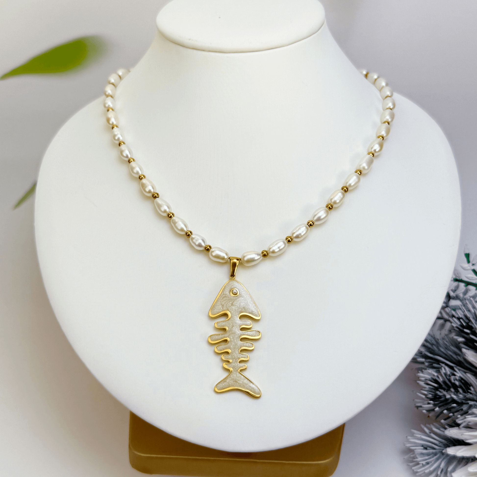 Pearl and gold fishbone necklace symbolising resilience and good fortune