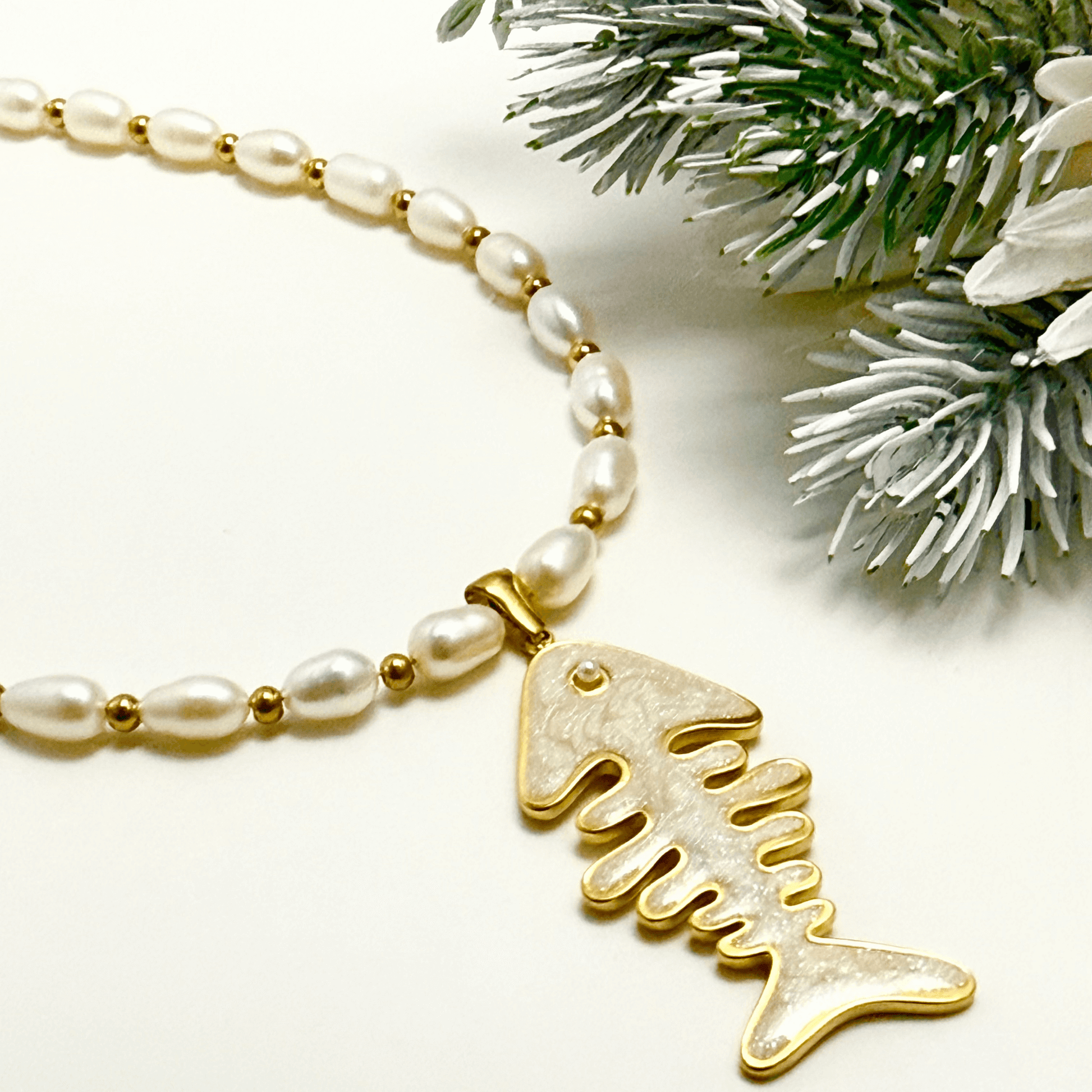 Pearl and gold fishbone necklace symbolising resilience and good fortune