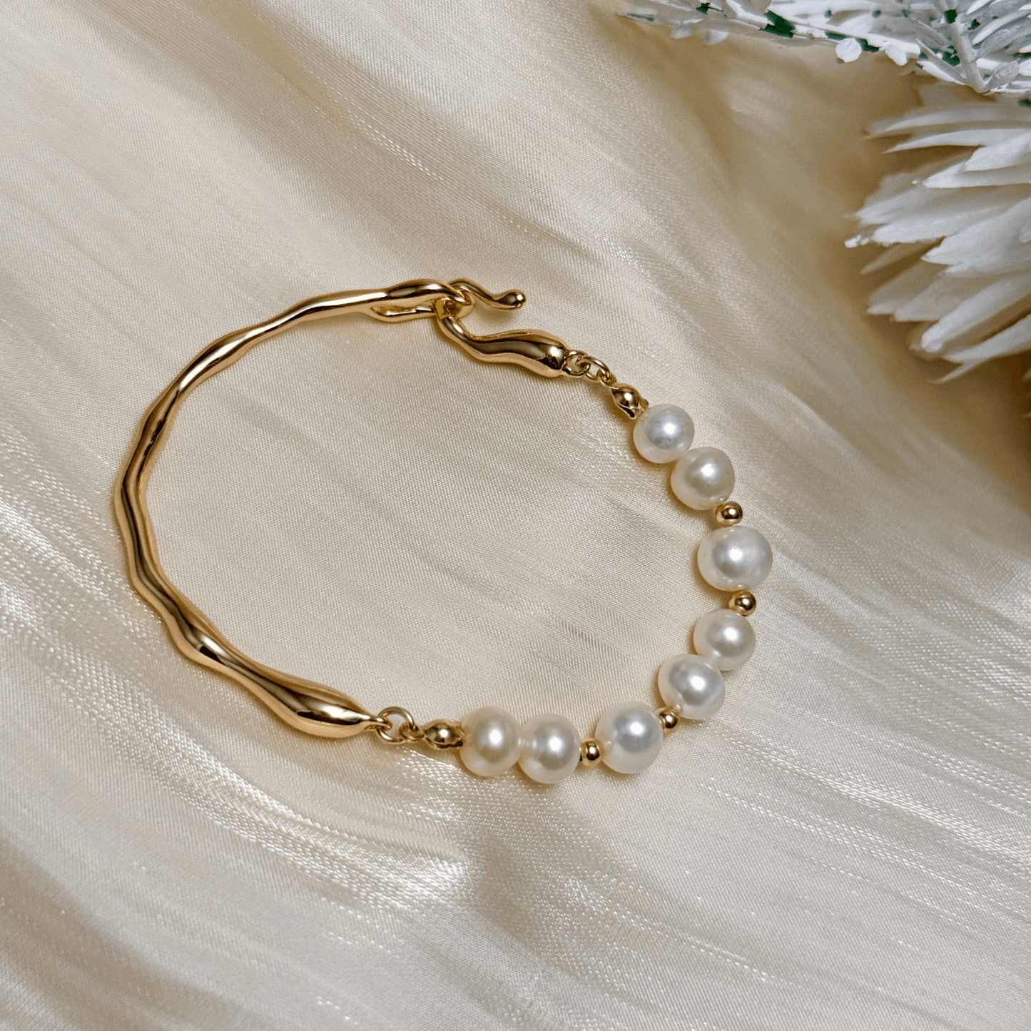 bracelet featuring freshwater pearls and sculptural molten gold band in an open, adjustable design