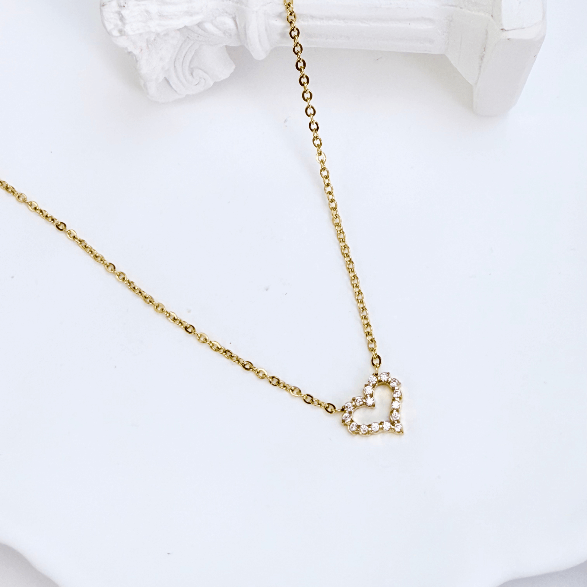 Gold necklace with pink zircon heart pendant, minimalist dainty design.