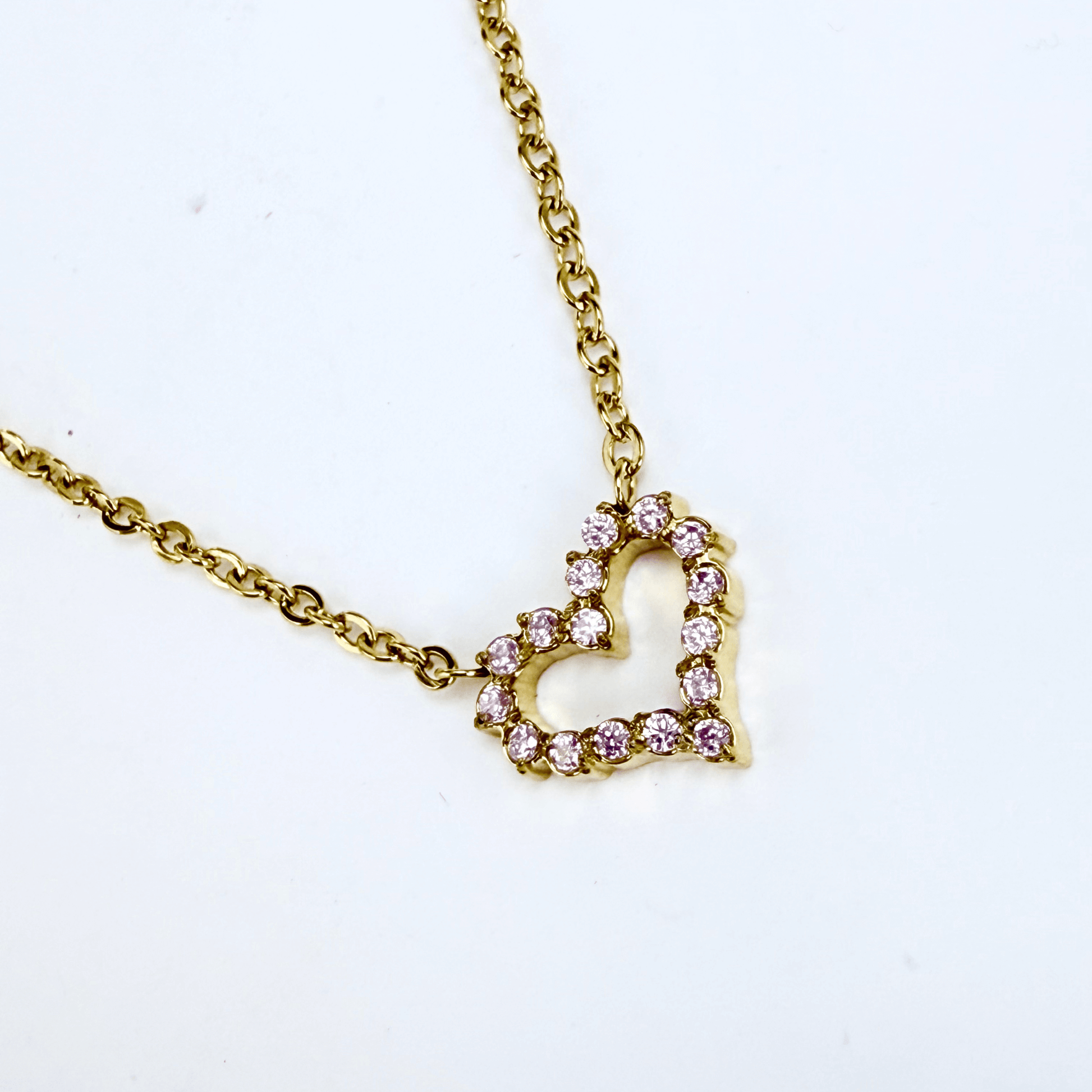 Gold necklace with pink zircon heart pendant, minimalist dainty design.