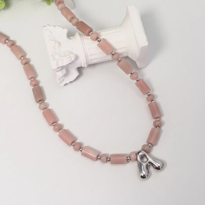 Pink opal initial necklace with barrel and rondelle beads, sterling silver spacers and a bubble letter pendant