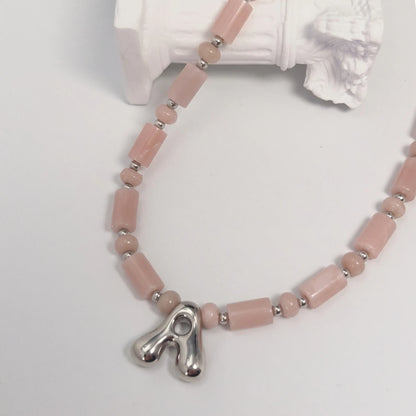 Pink opal initial necklace with barrel and rondelle beads, sterling silver spacers and a bubble letter pendant