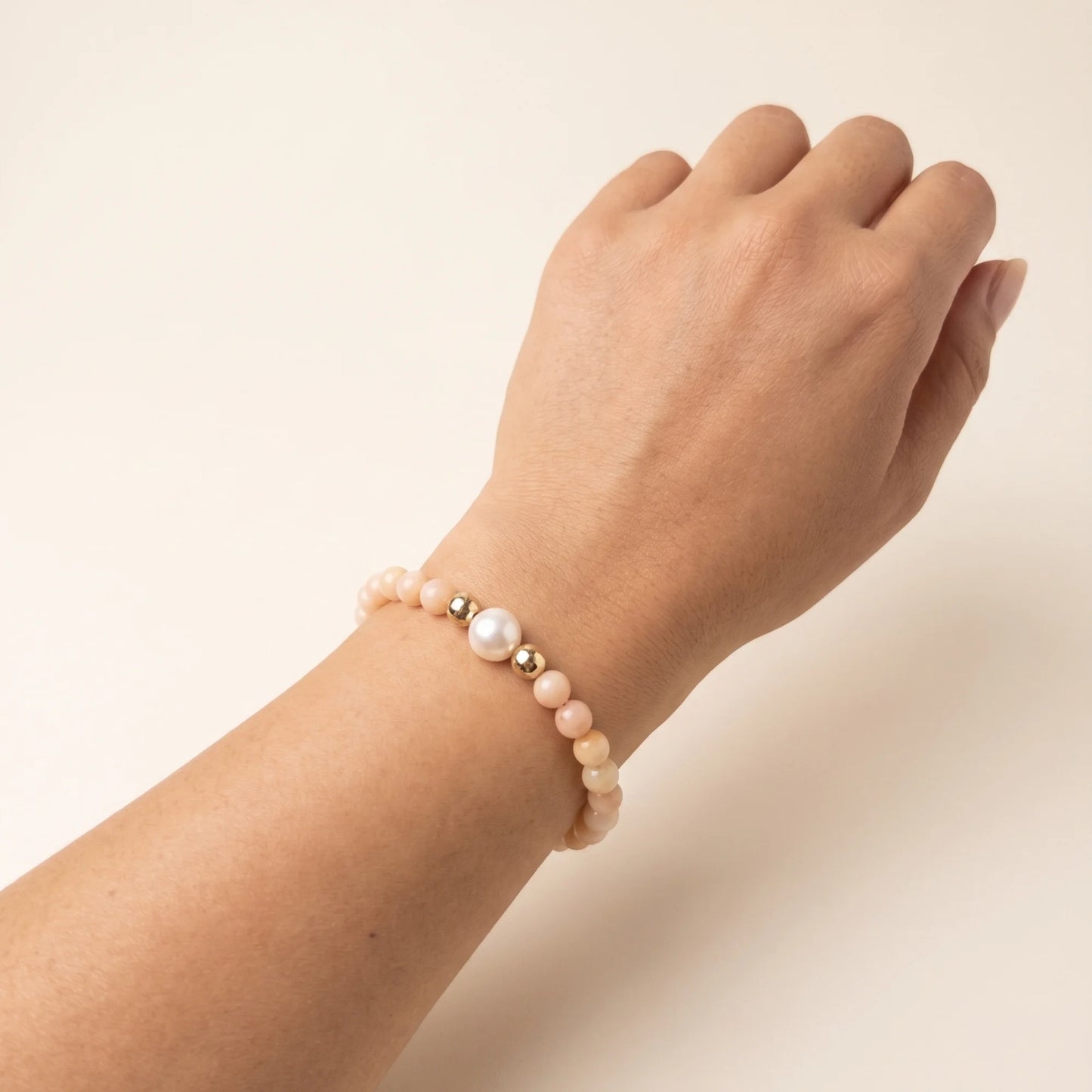 Pink opal, pearl and initial gold bracelet featuring soft pink gemstone beads, lustrous freshwater pearls and a personalised gold-filled stamped initial disc.