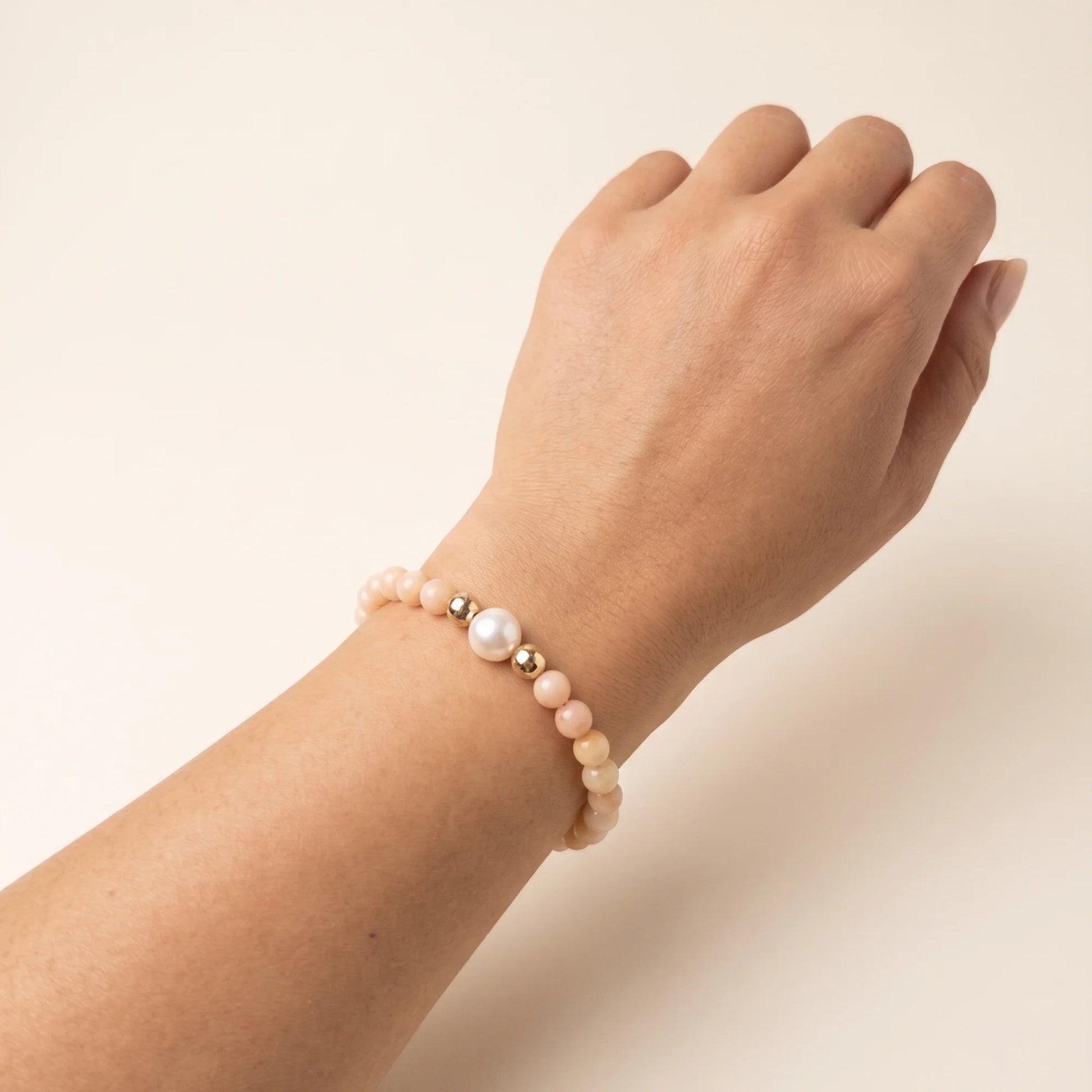 Pink opal, pearl and initial gold bracelet featuring soft pink gemstone beads, lustrous freshwater pearls and a personalised gold-filled stamped initial disc.