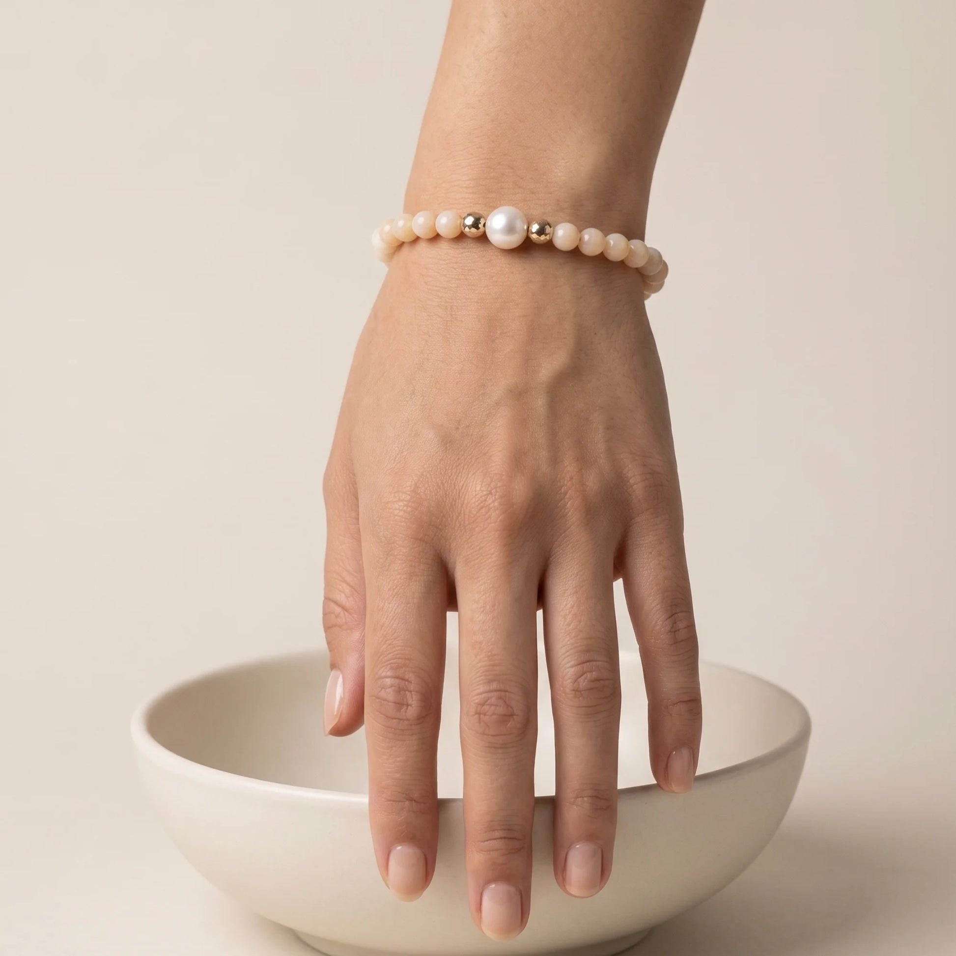 Pink opal, pearl and initial gold bracelet featuring soft pink gemstone beads, lustrous freshwater pearls and a personalised gold-filled stamped initial disc.