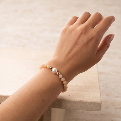 Pink opal, pearl and initial gold bracelet featuring soft pink gemstone beads, lustrous freshwater pearls and a personalised gold-filled stamped initial disc.