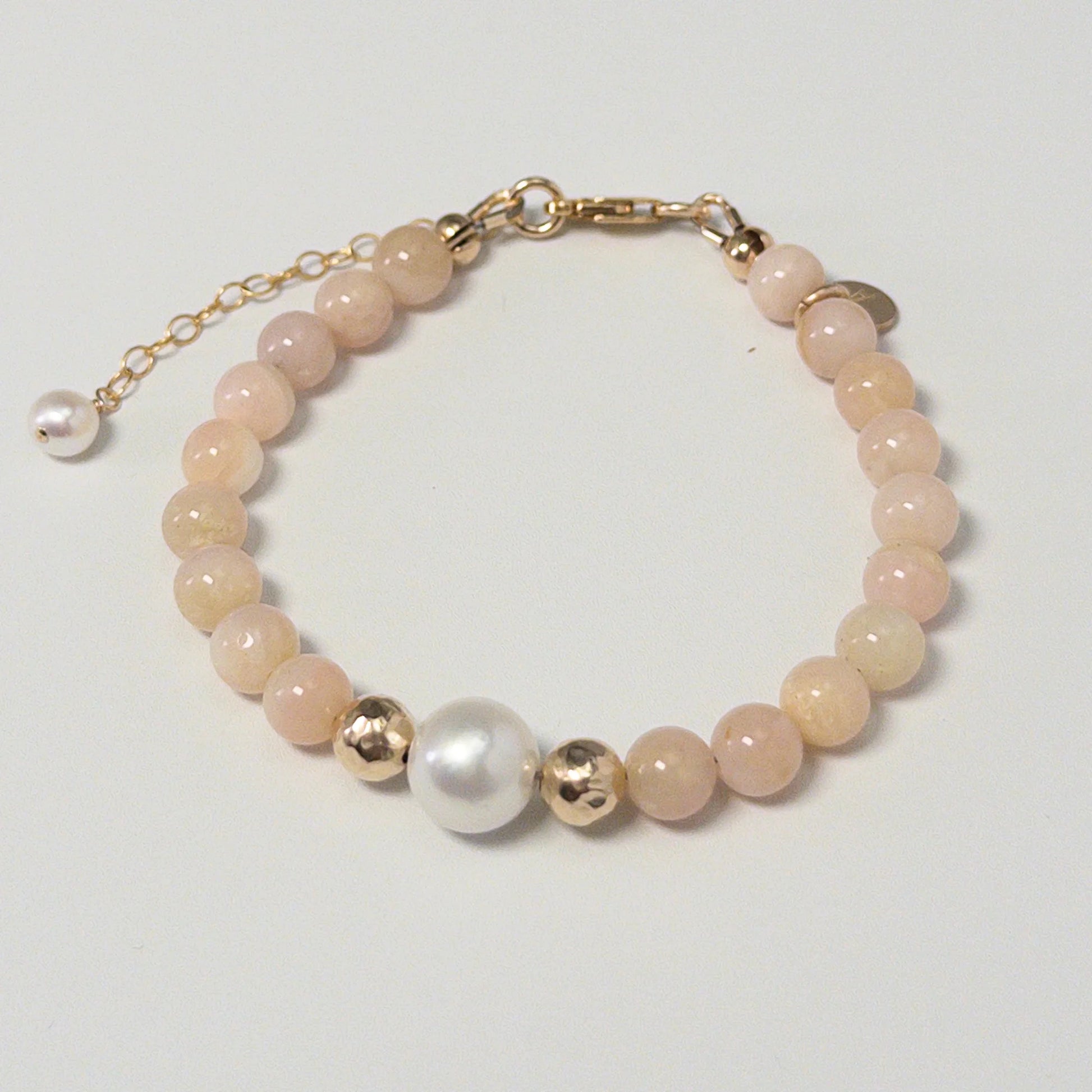 Pink opal, pearl and initial gold bracelet featuring soft pink gemstone beads, lustrous freshwater pearls and a personalised gold-filled stamped initial disc.