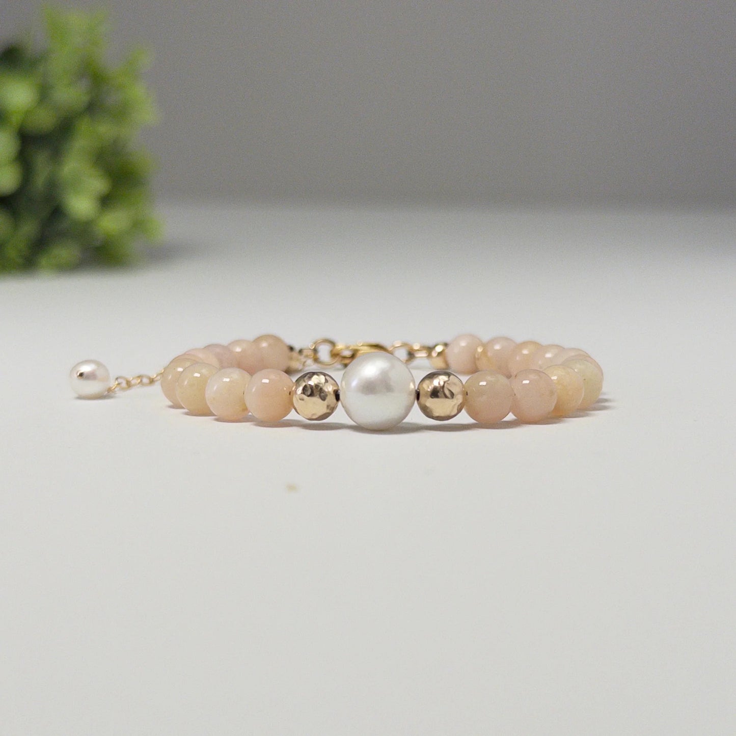 Pink opal, pearl and initial gold bracelet featuring soft pink gemstone beads, lustrous freshwater pearls and a personalised gold-filled stamped initial disc.