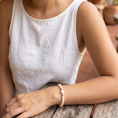 Pink opal, pearl and initial gold bracelet featuring soft pink gemstone beads, lustrous freshwater pearls and a personalised gold-filled stamped initial disc.