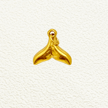 Shiny gold whale tail charm with smooth finish