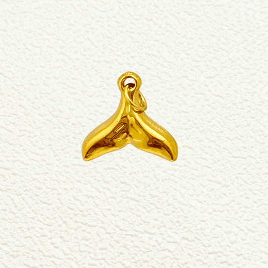 Shiny gold whale tail charm with smooth finish