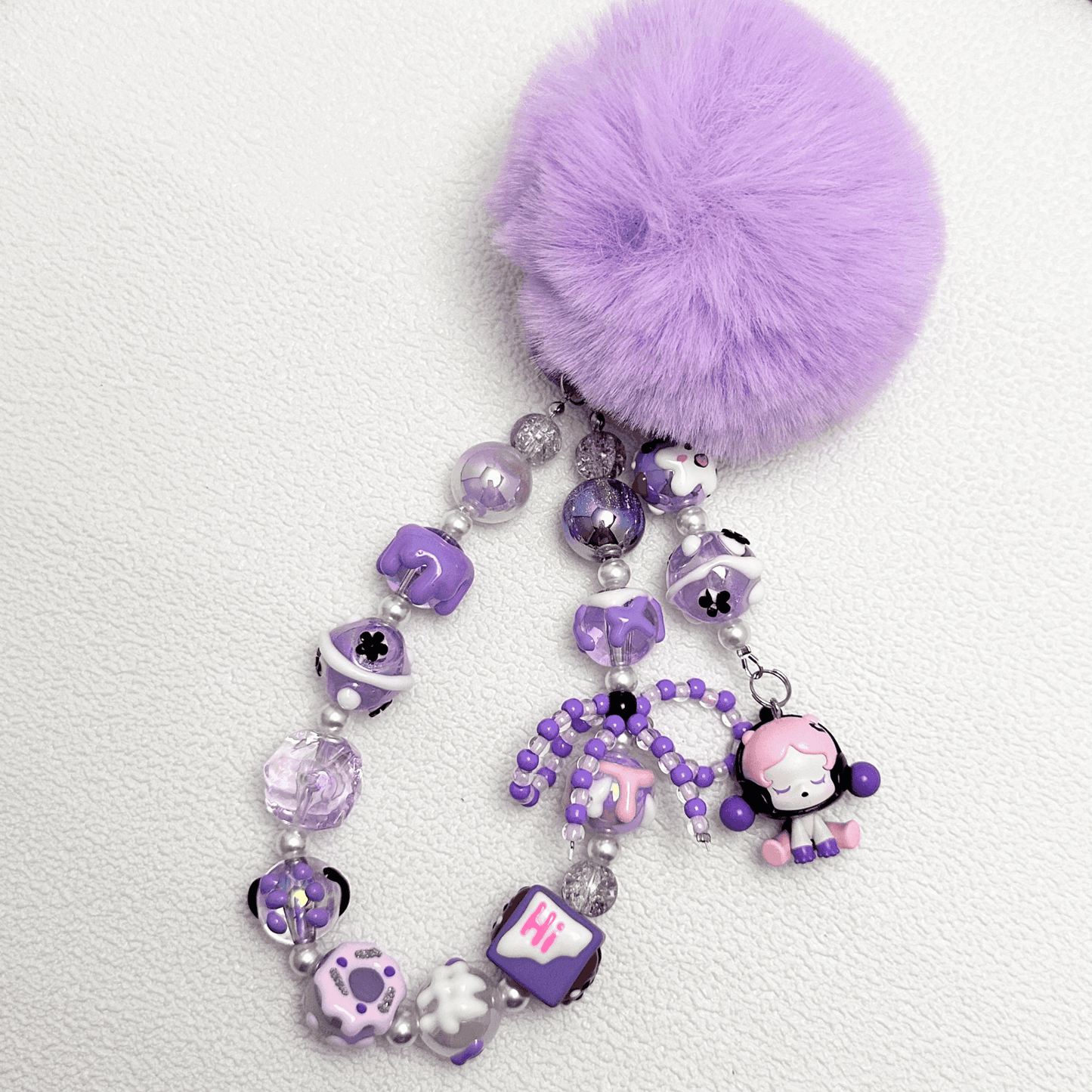 Handmade Pop Bean purple sitting sp phone charm with hand-painted polymer clay beads and faux pearls, attached to a keychain.