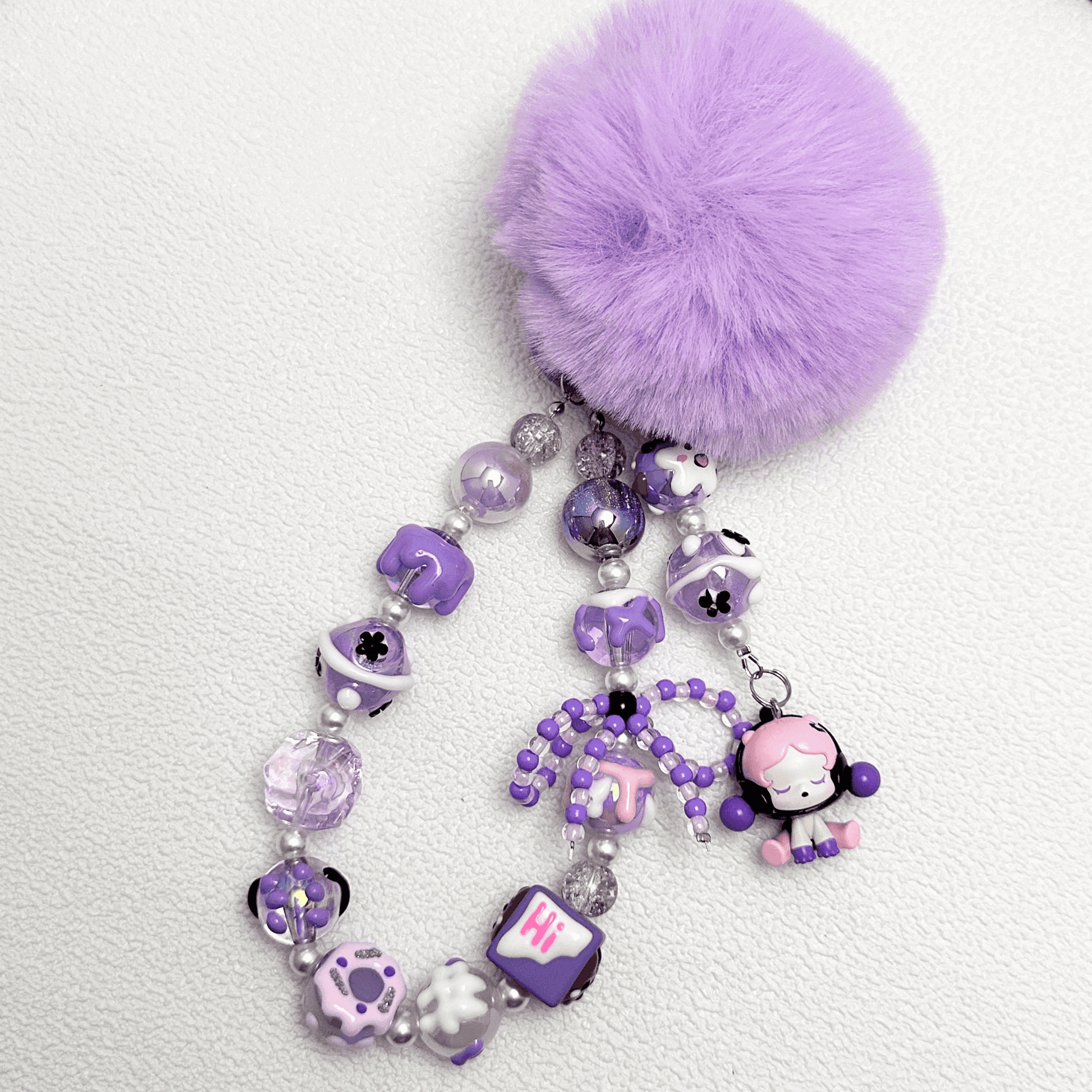 Handmade Pop Bean purple sitting sp phone charm with hand-painted polymer clay beads and faux pearls, attached to a keychain.
