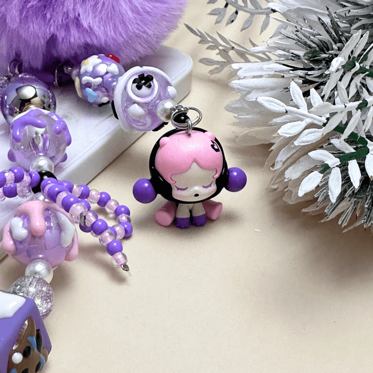 Handmade Pop Bean purple sitting sp phone charm with hand-painted polymer clay beads and faux pearls, attached to a keychain.