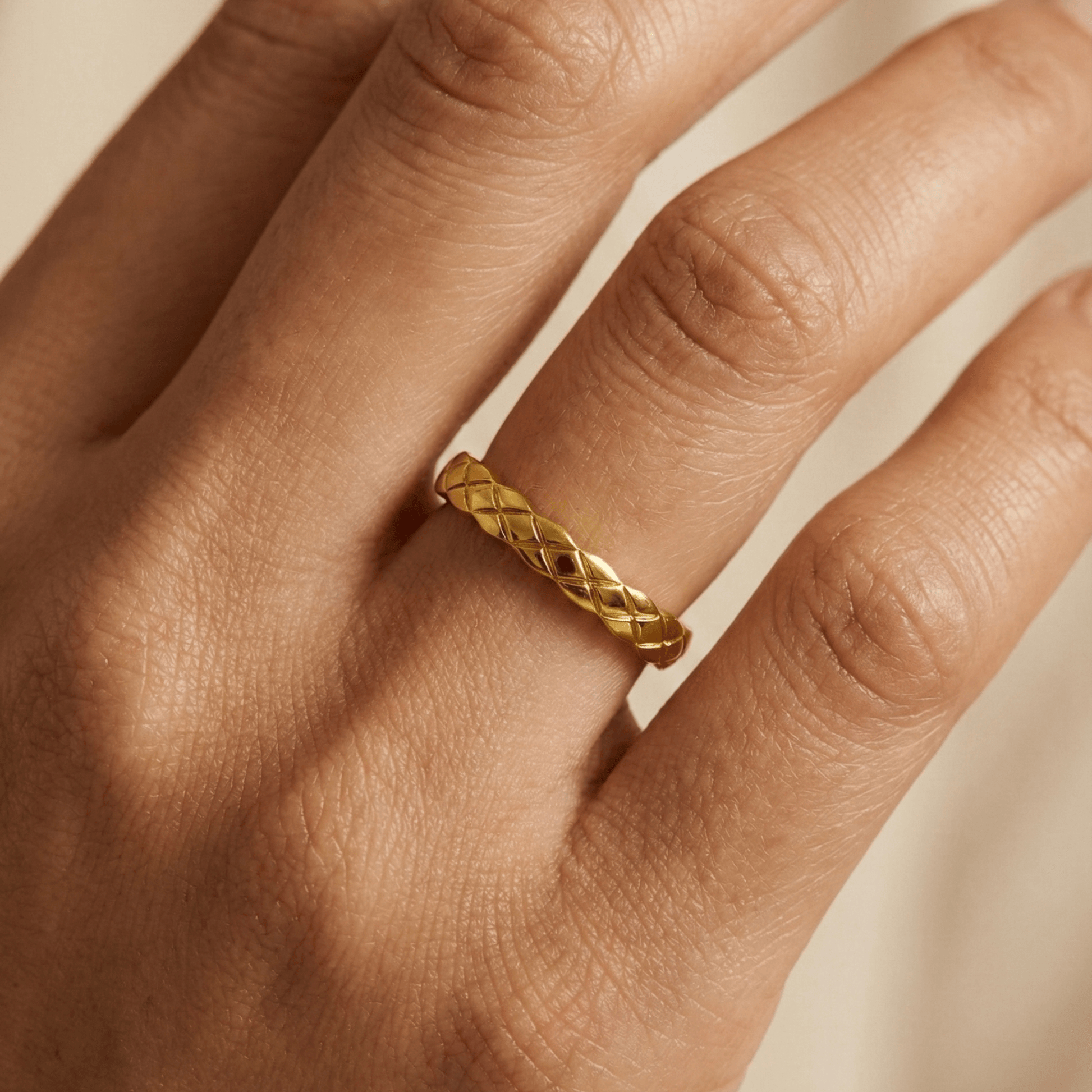 Slim quilted gold band ring with textured designer-inspired pattern.